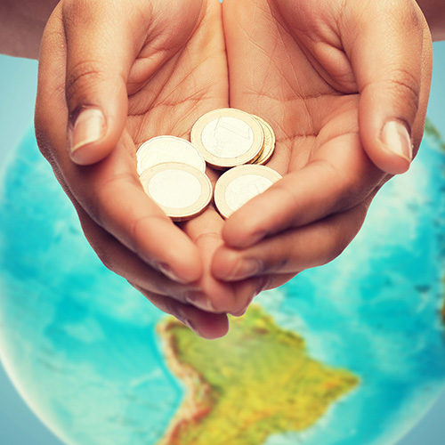 cupped hands holding euro coins over earth globe